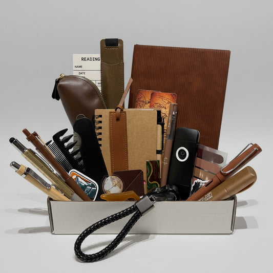 Collection of stationery items including notebooks, pens, and a phone on a white surface.