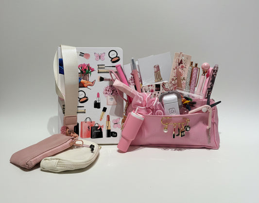 A pink zippered cosmetic bag filled with pens, pencils, and stationery, displayed alongside a matching pink pouch and a cream pouch on a white desk in front of clear storage drawers.