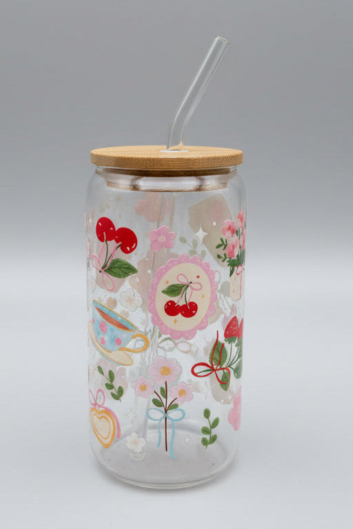 Glass tumbler with wooden lid and colorful designs on a cardboard background