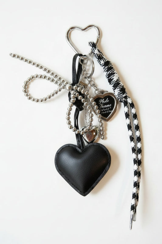 Keychain with heart-shaped pouch and charms on a white background