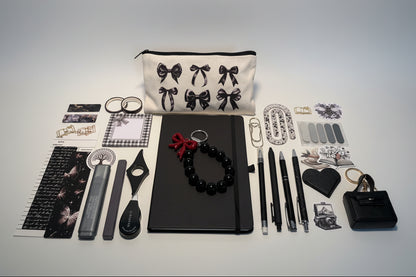 Desk with black stationery items and a decorative pillow with bow patterns.