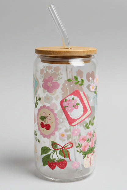 Decorative glass tumbler with floral patterns and a wooden lid on a cardboard background