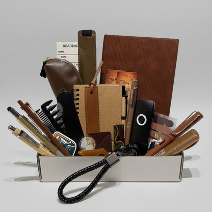 Collection of stationery items including notebooks, pens, and a phone on a white surface.