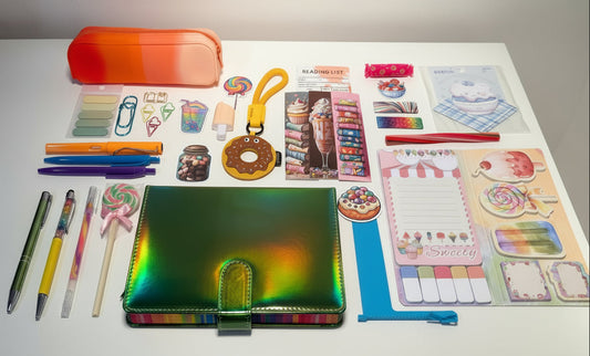 Assorted colorful stationery items including pens, notebooks, and decorative stickers on a white surface.