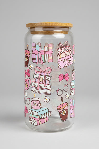 Decorative glass jar with pink and white designs on a wooden surface