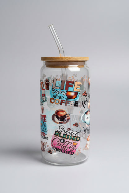 Glass tumbler with coffee-themed design and text on a wooden surface outdoors.