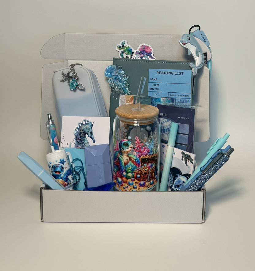 Collection of ocean theme stationery items including pens, cards, and a cup with decorative elements on a desk.