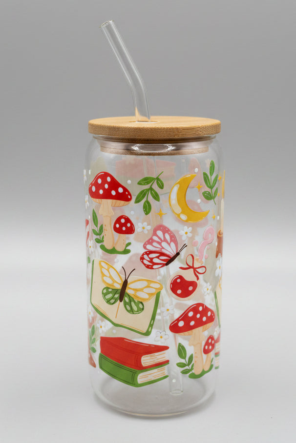Glass tumbler with wooden lid and colorful nature-themed design on a cardboard background