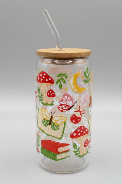 Glass tumbler with wooden lid and colorful nature-themed design on a cardboard background
